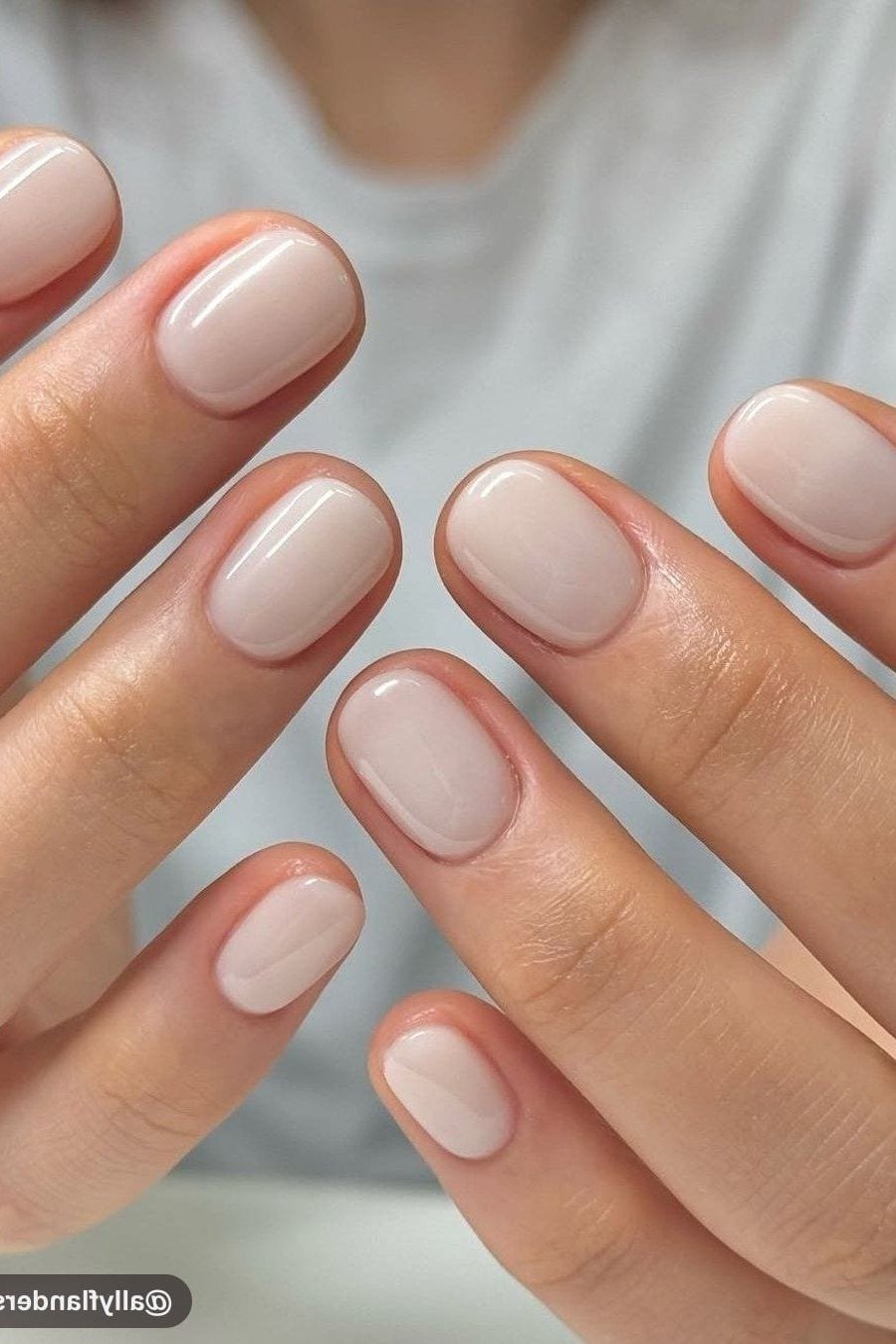 Short milky white oval nails, two hands, builder gel manicure for women over 50