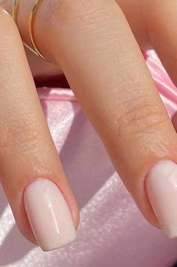 Milky white short square nails on pink fabric backdrop, builder gel over 50