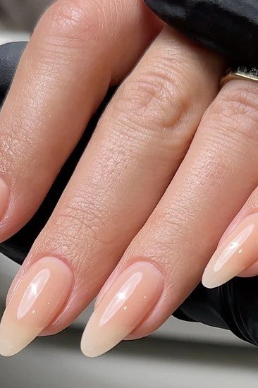 Nude almond nails with black glove backdrop, builder gel manicure