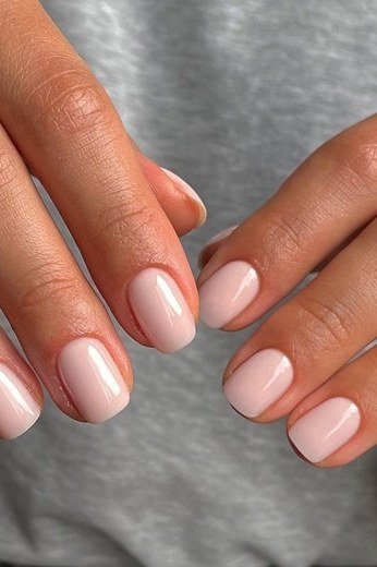 Pink-nude almond nails, two hands with rings, builder gel for women over 50