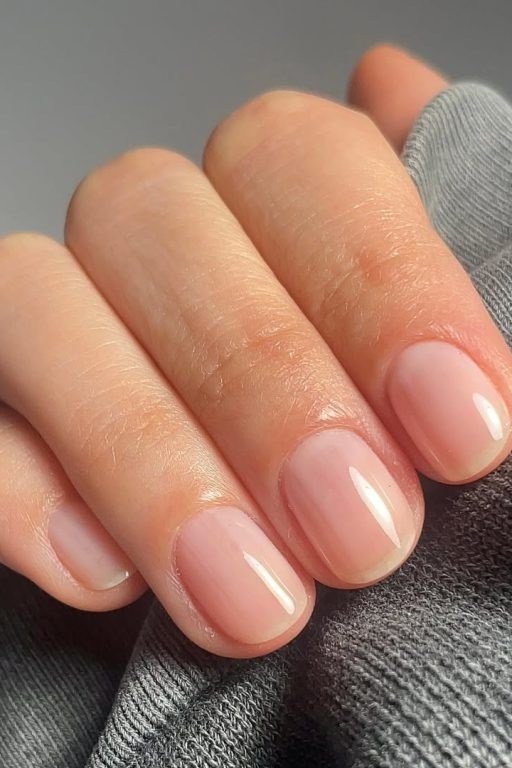 Milky-nude oval nails close-up, builder gel manicure for women over 50