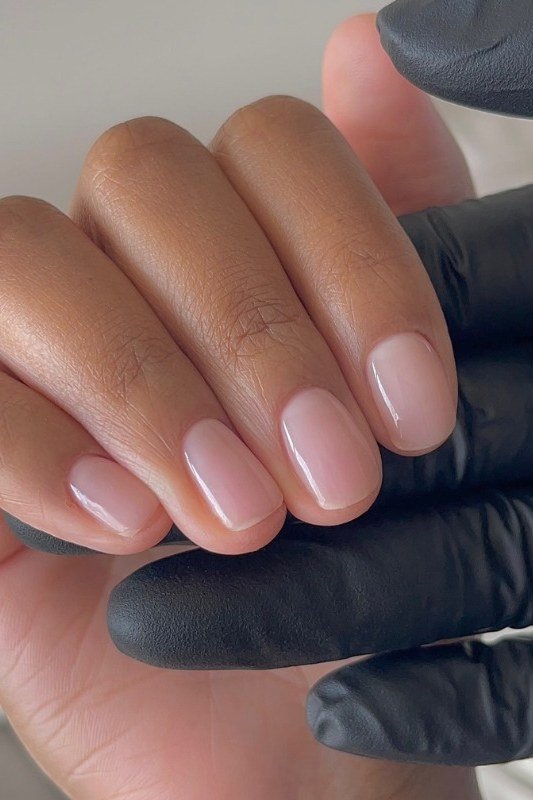 Pinky-nude almond nails with black glove backdrop, builder gel over 50