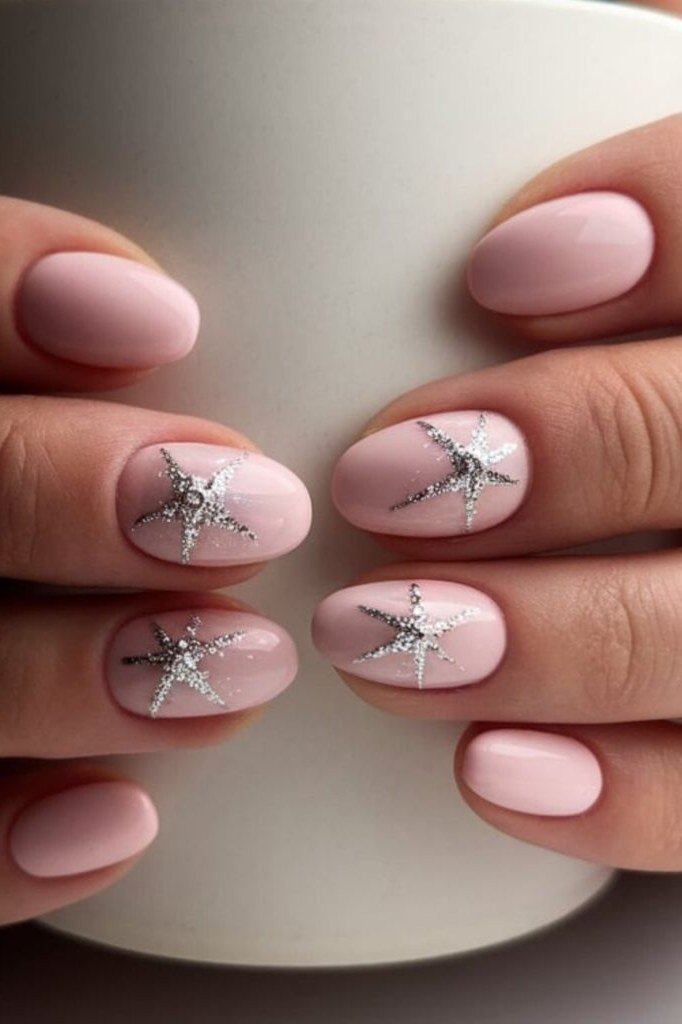 Soft pink nails with silver star accents beside coffee mug, builder gel