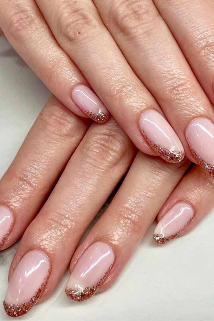 Pink nails with glitter tips, hands crossed, builder gel over 50