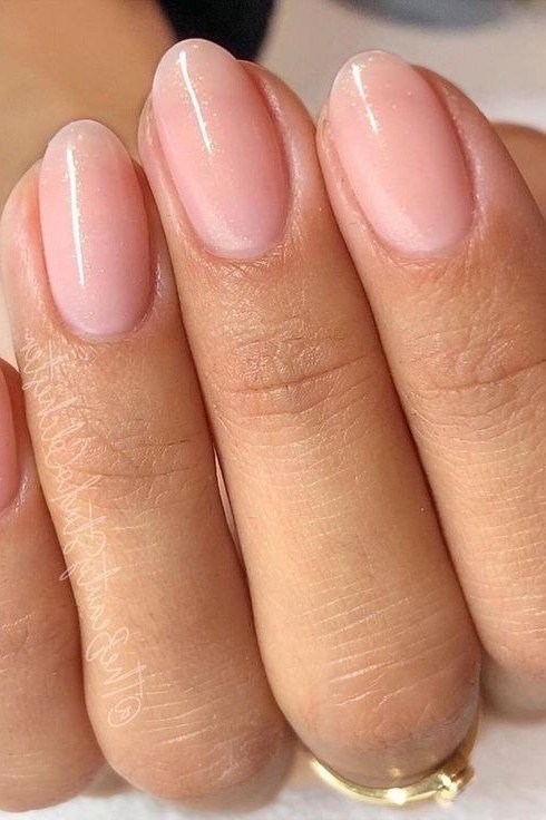 Pink-nude almond nails close-up, builder gel manicure for women over 50