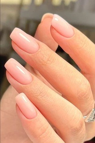 Peachy-pink almond nails close-up, builder gel manicure for women over 50