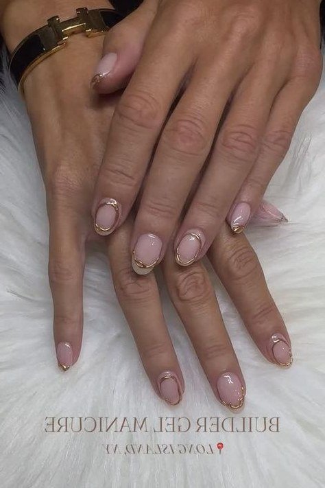 Nude builder gel nails on mature hand with rings, women over 50