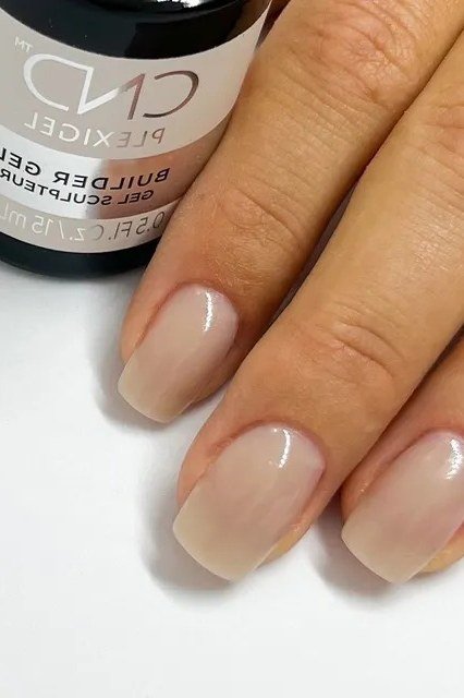 Short nude square nails with builder gel bottle at salon, manicure over 50