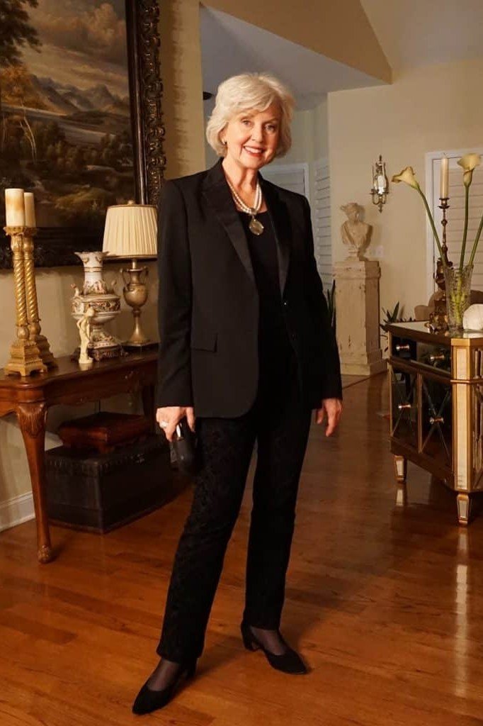 black blazer suit for women over 50 with pendant necklace indoors