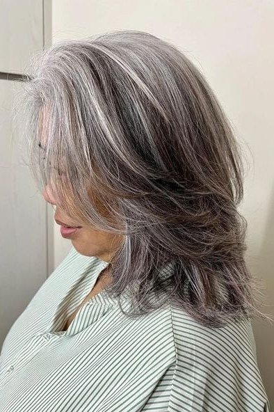 Grey Feathered Waves - shoulder-length blowout hairstyle for women over 60