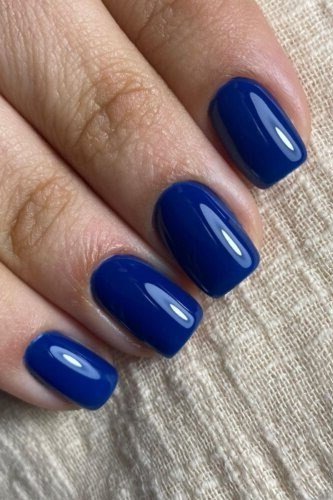 Royal blue short square nails with a glossy finish for women over 50