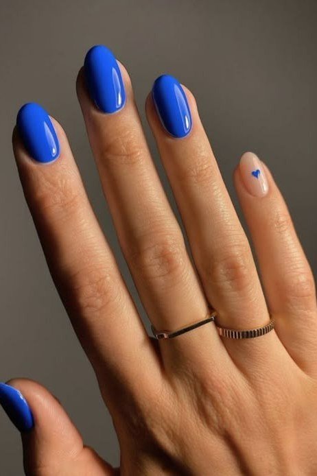 Royal blue almond nails with thin gold rings for women over 50