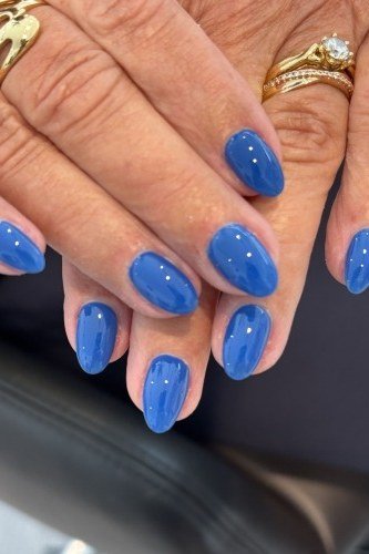 Glossy royal blue almond nails with gold bands for women over 50