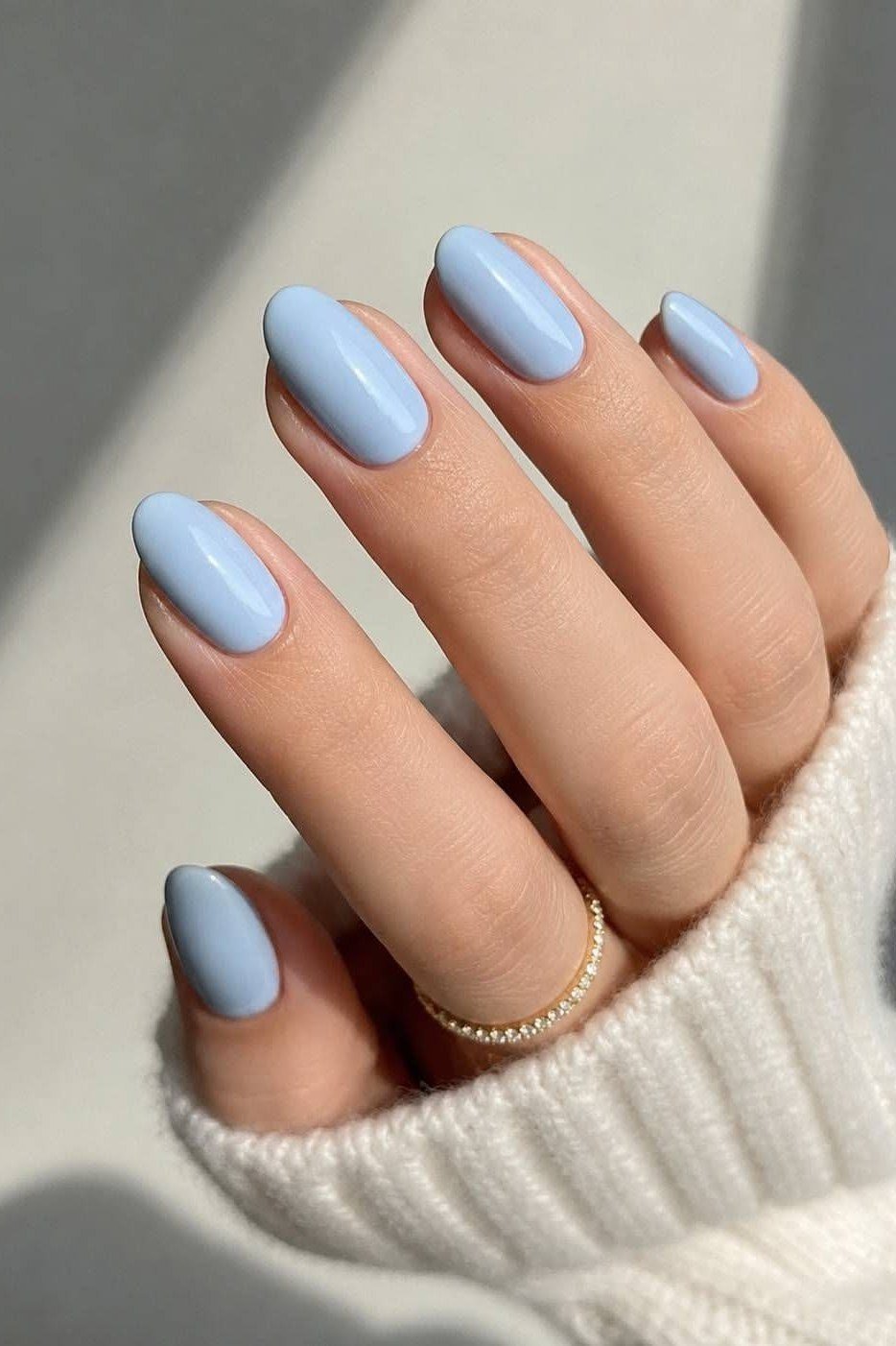Light blue almond nails with a white sweater for women over 50