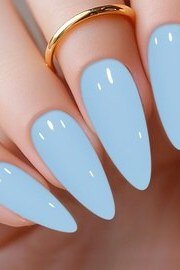 Light blue glossy stiletto nails with a gold ring for women over 50