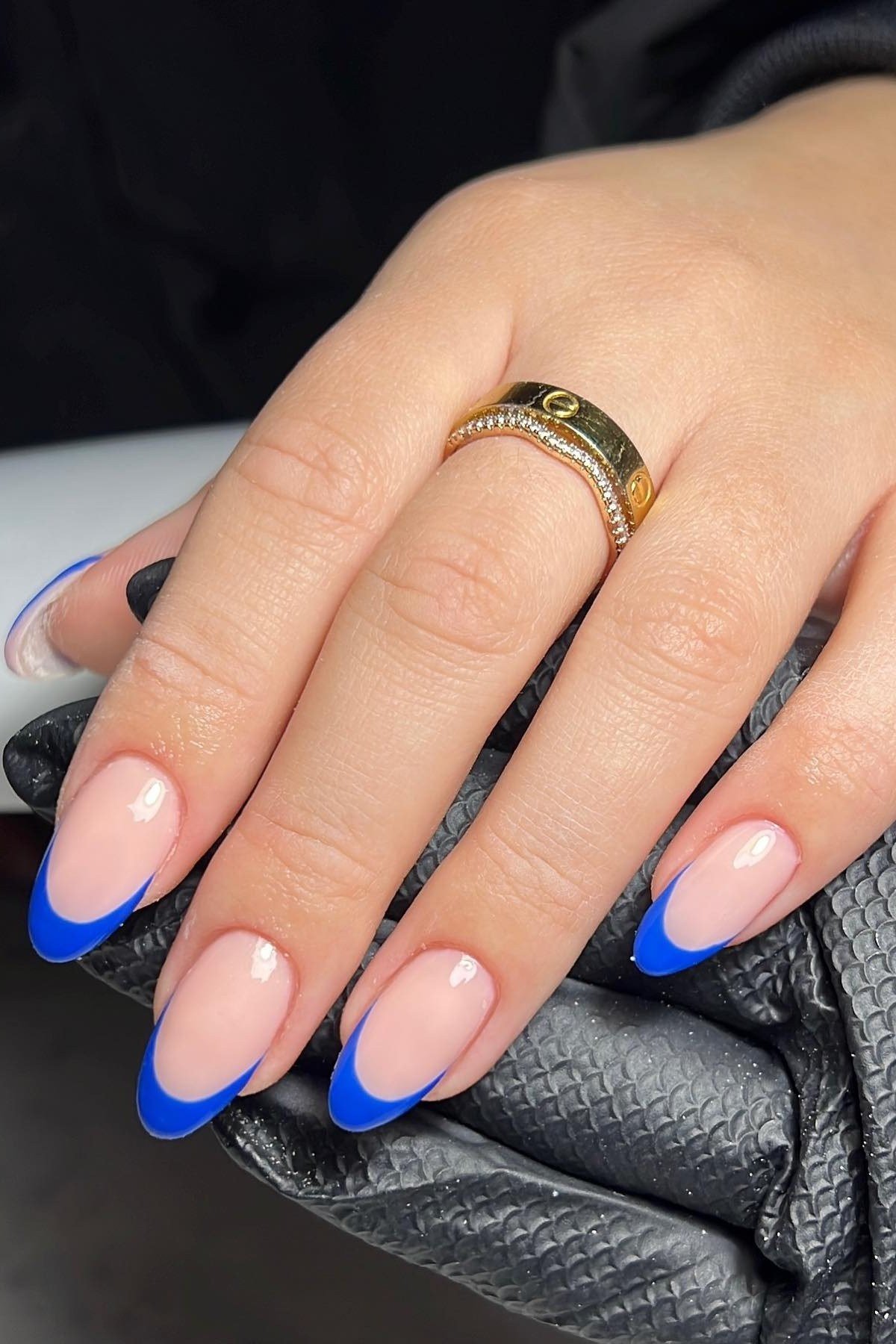 Royal blue french nails with a gold ring for women over 50