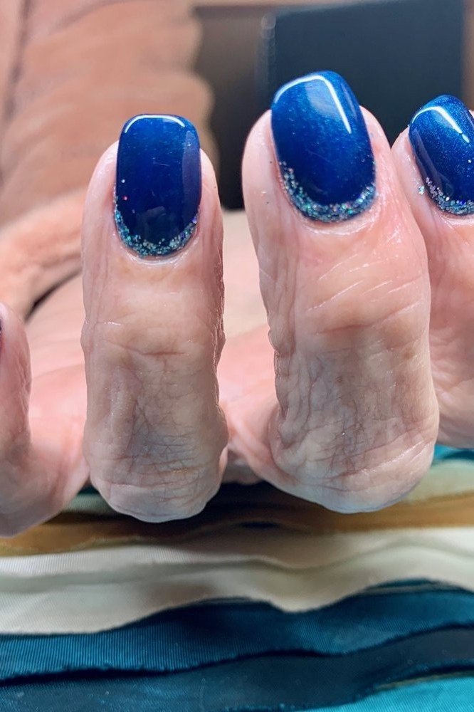 Royal blue nails with silver glitter fade for women over 50