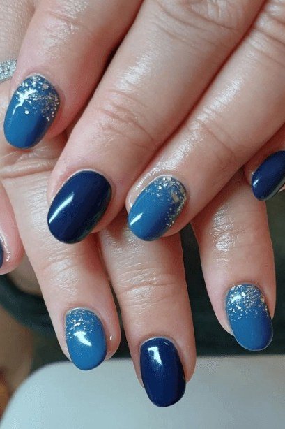 Navy and blue nails with silver glitter tips on mature hands for women over 50