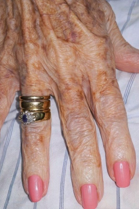Deep Red Nails With Gold Watch - flattering nail color for women over 70 on mature hands