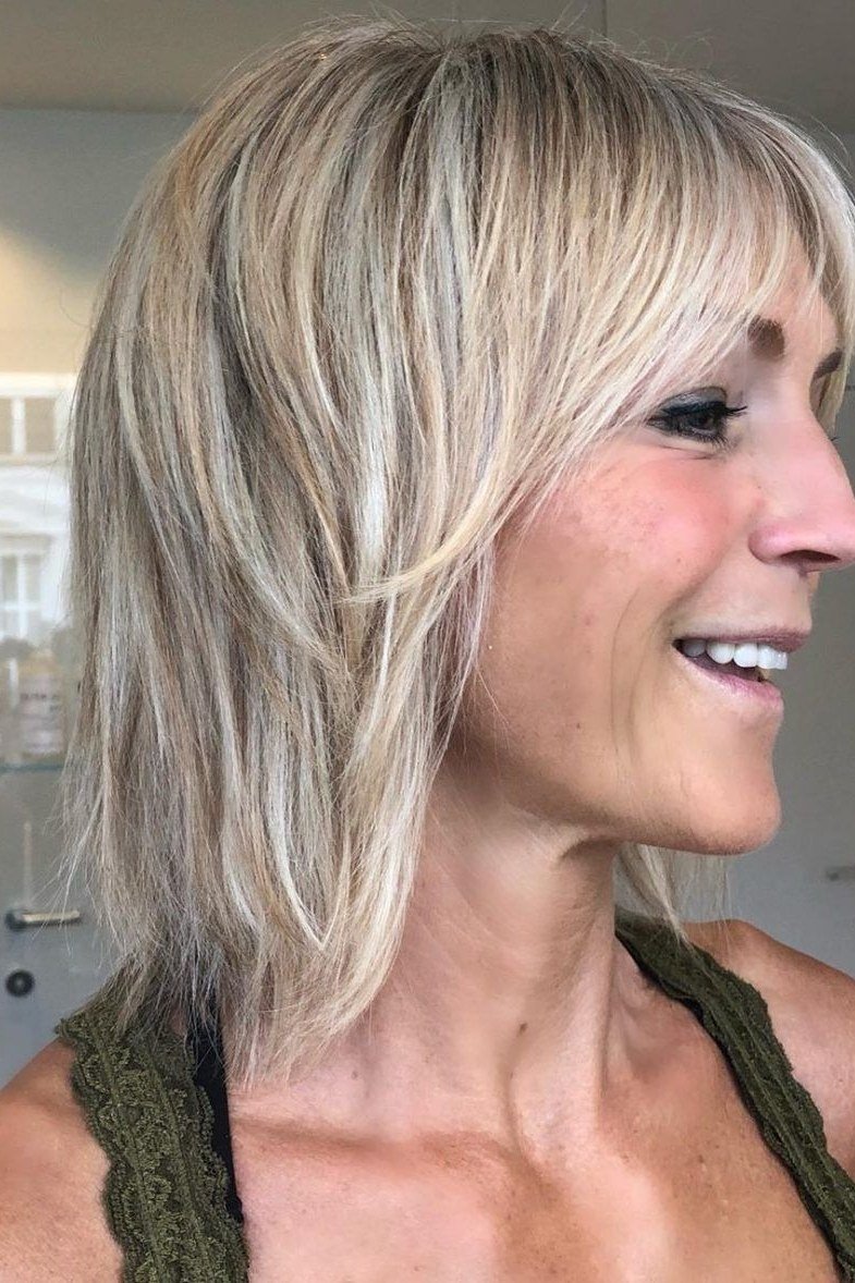 Ash blonde layered bob with side swept bangs for women over 60