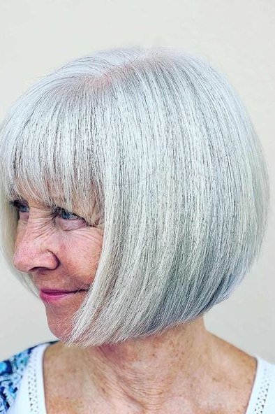 White blunt bob with straight fringe hairstyle for women over 60