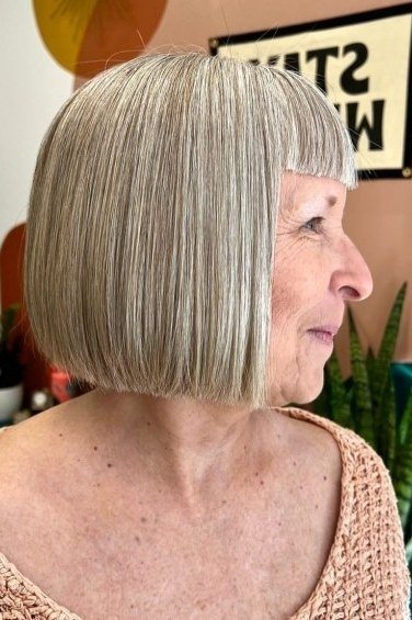 Silver pageboy bob with straight fringe hairstyle for women over 60