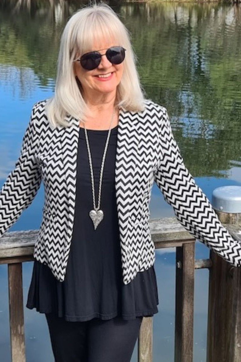 Black/white zigzag cardigan, black top, long heart pendant, lake dock, casual outfit for women over 50