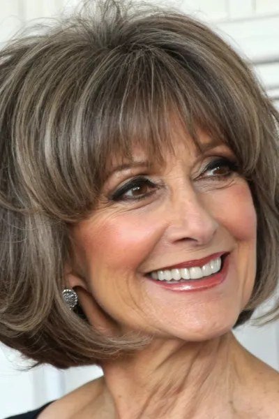 ash-brown layered bob with bangs, smiling three-quarter view - layered bob curtain bangs over 50, idea 28