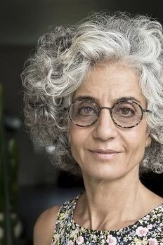 Grey curly bob with round glasses for women over 70