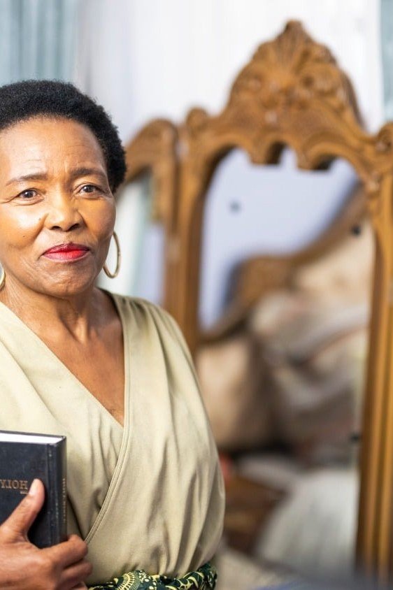 church dresses for women over 60: older woman in cream wrap dress with bible