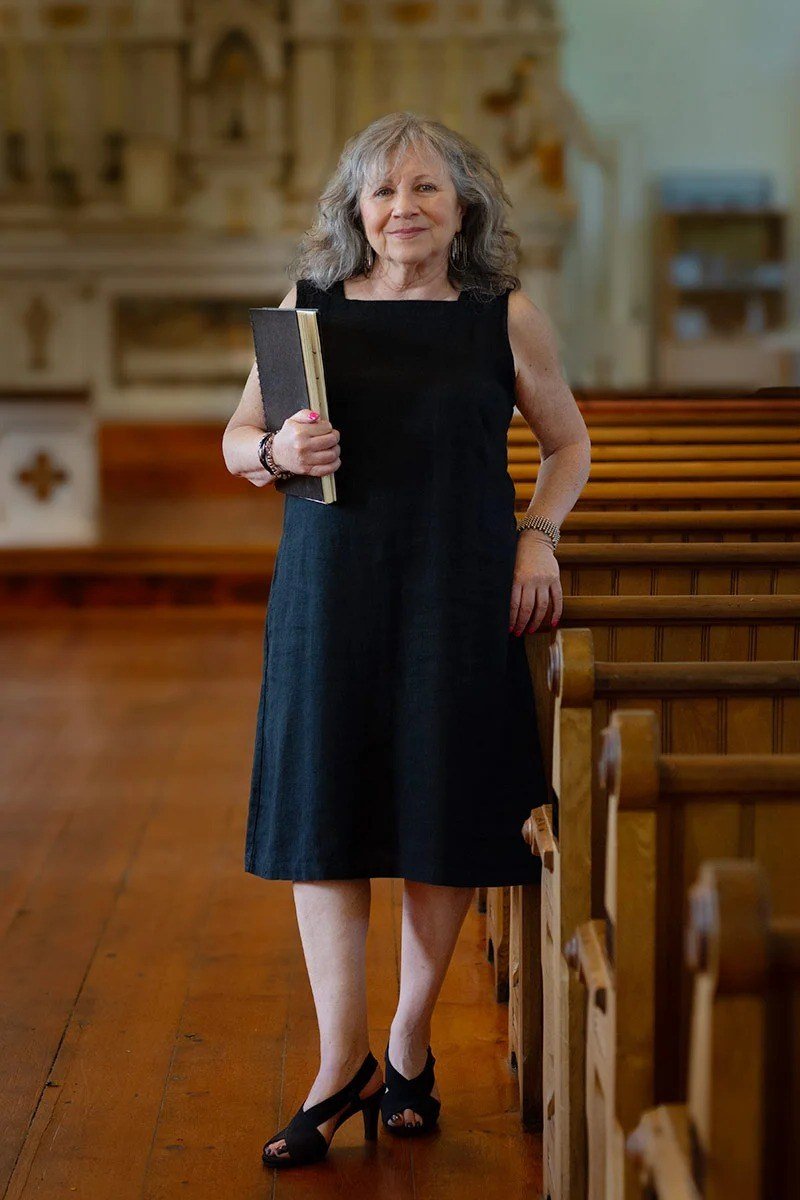 church dresses for women over 60: older woman in classic black sleeveless midi dress