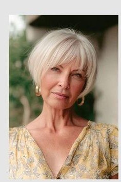 Platinum white bob with feathered bangs for women over 70