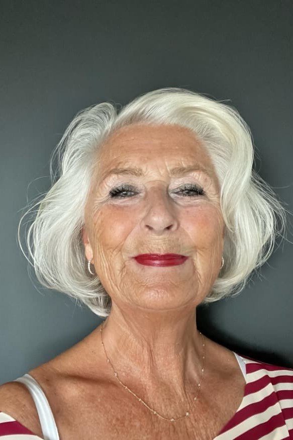 Elegant silver choppy bob for women over 70 with red lipstick