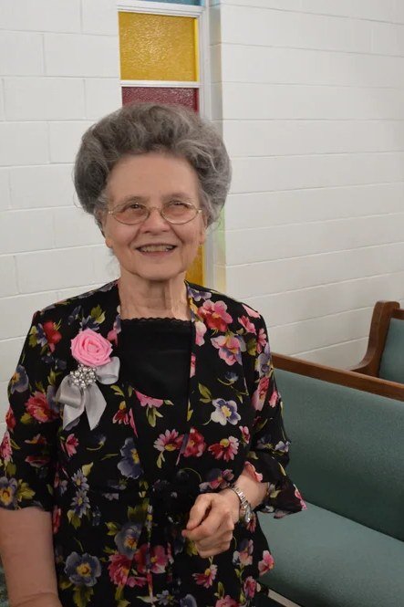 Black floral dress seated in church pew for women over 60