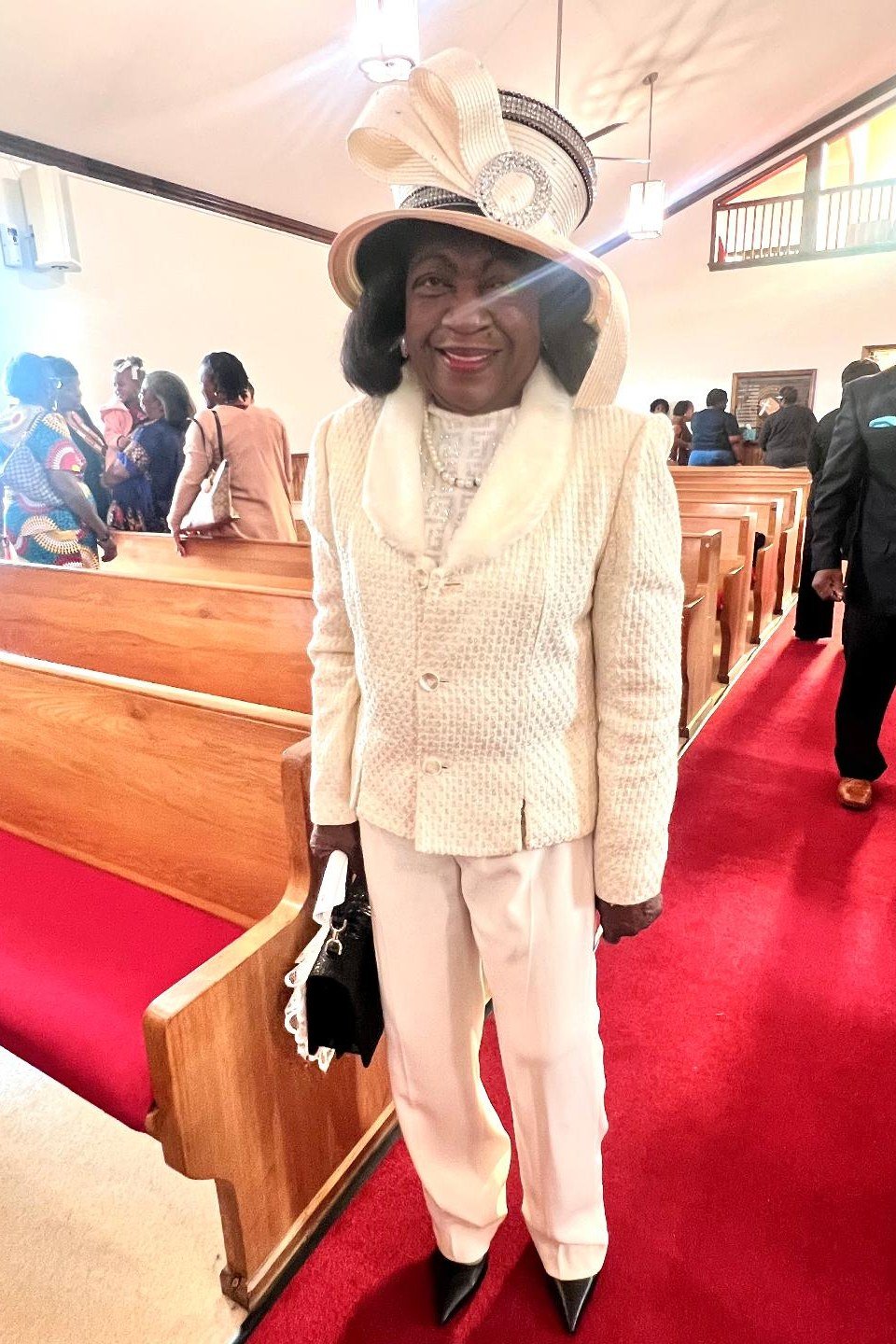 Cream skirt suit with statement hat, church aisle for women over 60