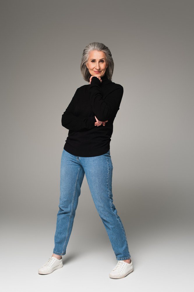 Black turtleneck with light-wash jeans in a studio, minimalist casual outfit for women over 50