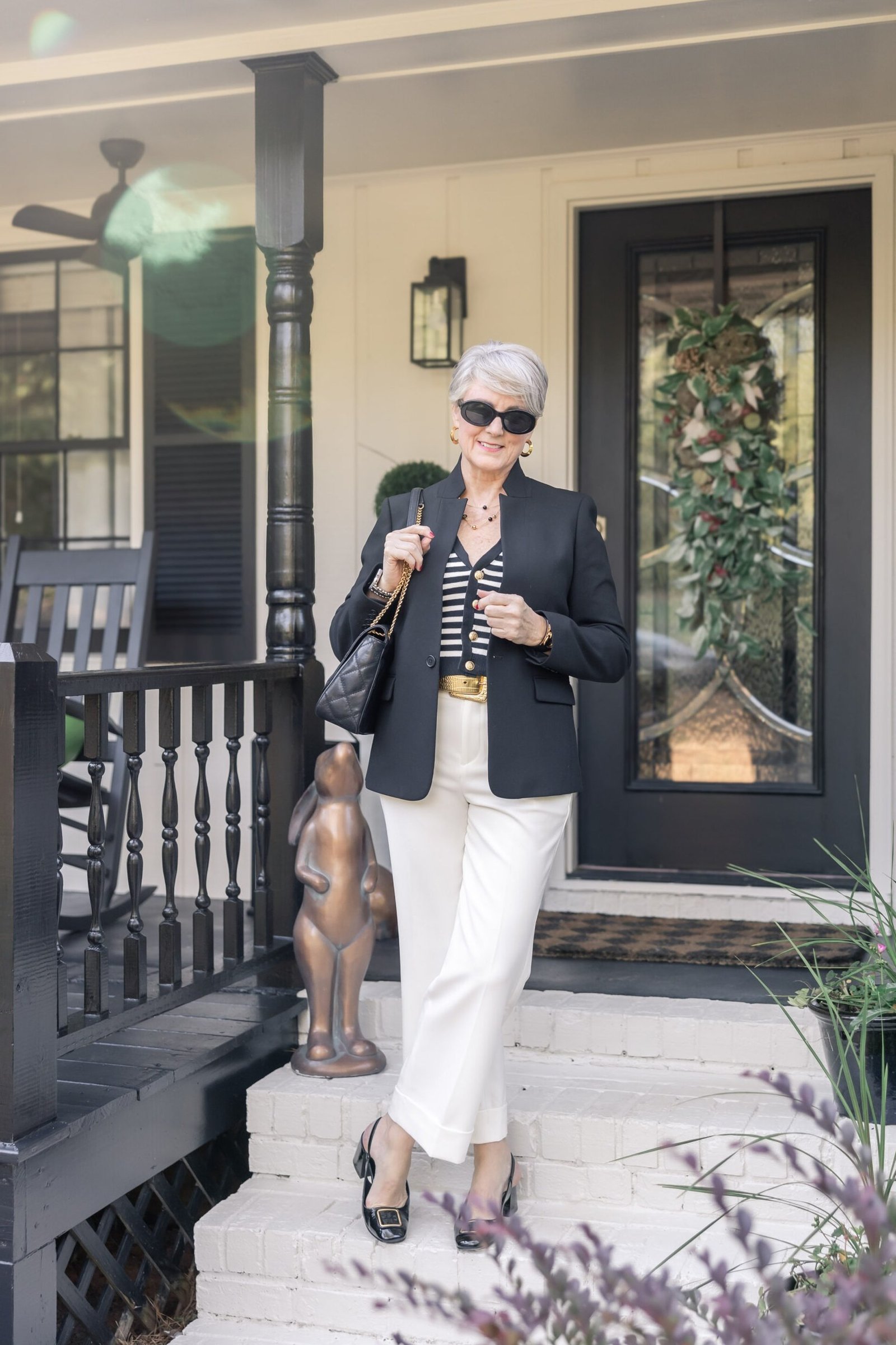 Black and white striped blazer over black top and white pants, classy casual outfit idea for women over 60