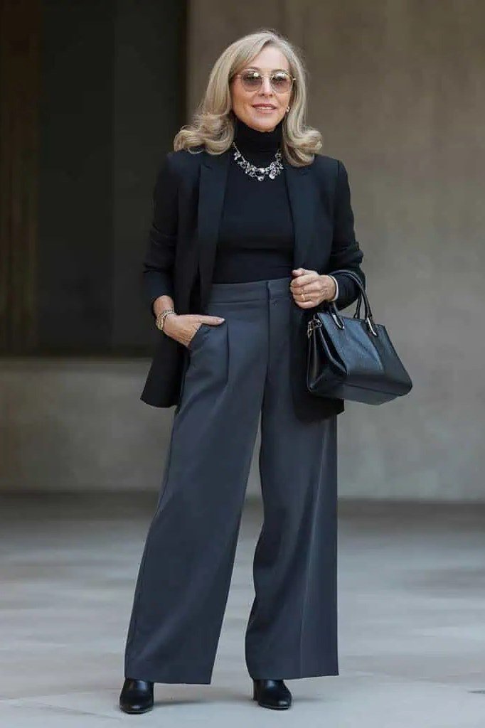 Woman over 50 in black blazer and slate wide-leg trousers