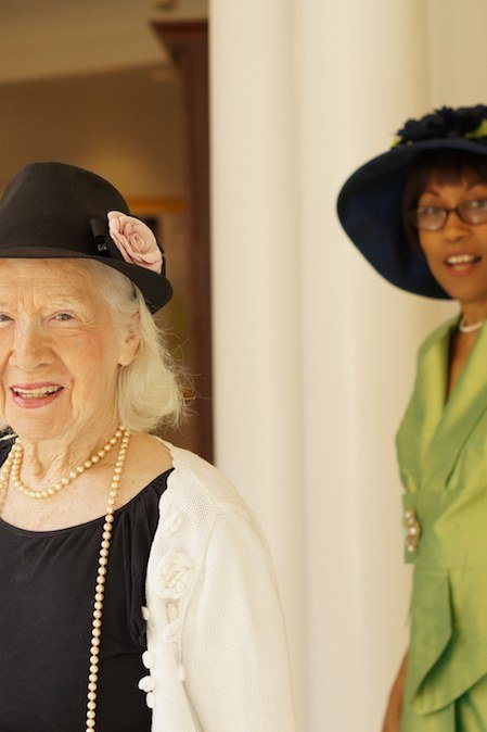 Older woman in lime green suit with matching hat in church