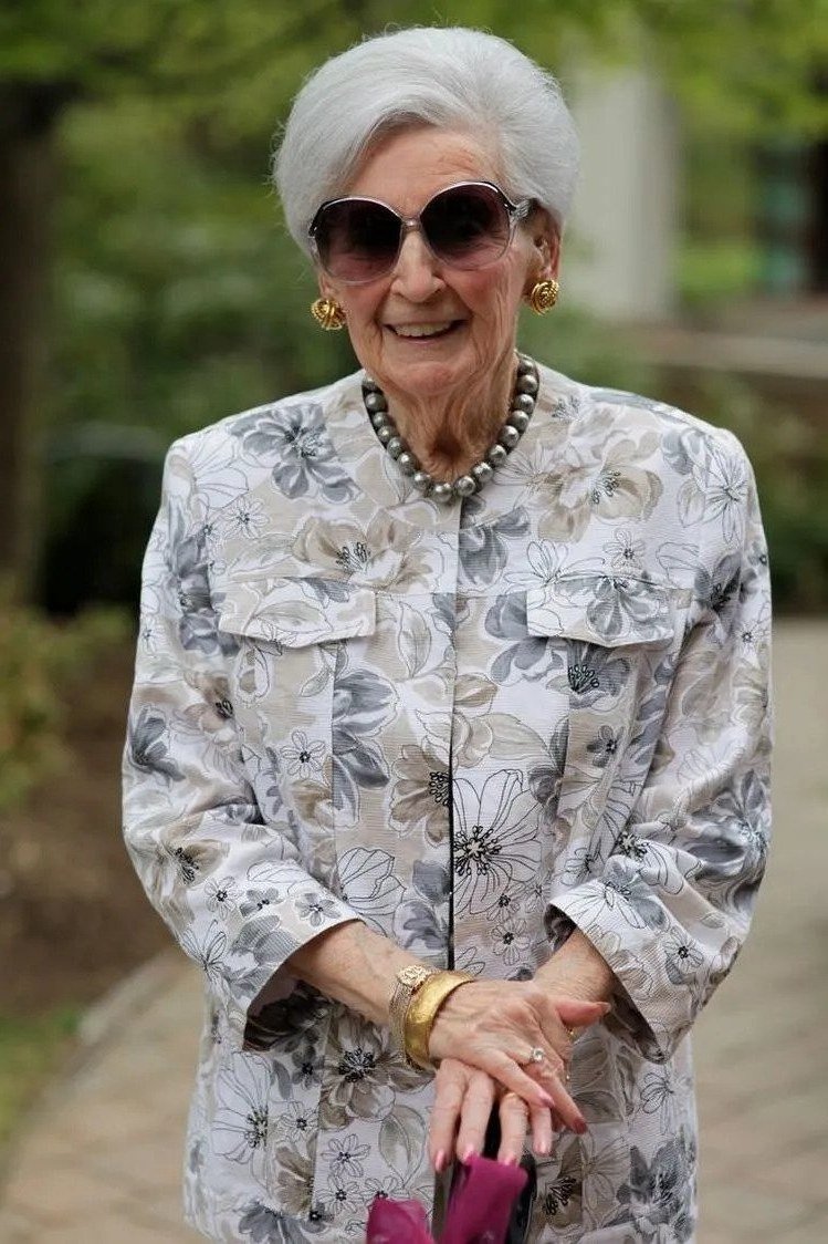Older woman in floral print jacket with sunglasses outdoors