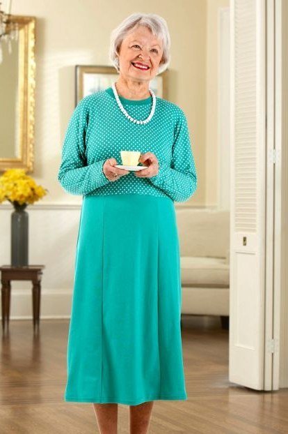 Older woman in turquoise knit midi dress with pearl necklace