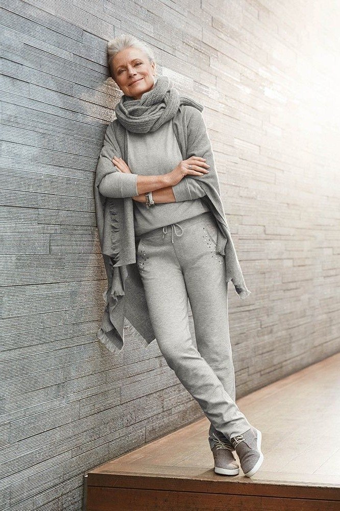 Grey knit set (sweater and joggers) leaning on brick wall - cozy casual outfit idea for women over 50