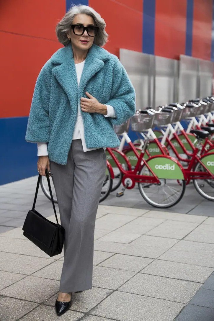 Blue teddy coat with grey wide pants and black handbag - cozy casual outfit idea for women over 50