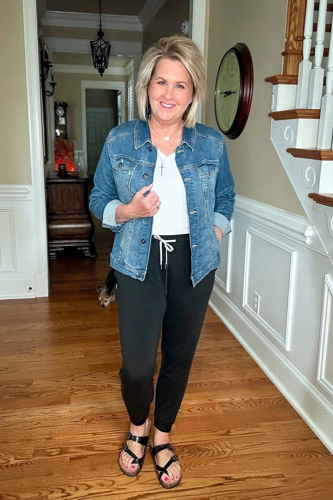 Denim jacket with black joggers and sandals, indoors - cozy casual outfit idea for women over 50