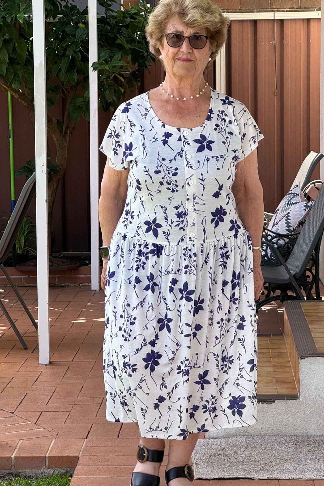 White midi dress with navy floral print on patio