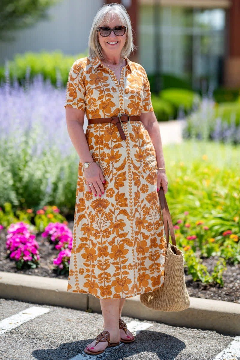 Orange floral shirt dress with brown belt in garden