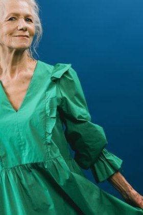 Emerald green ruffle v-neck dress in studio