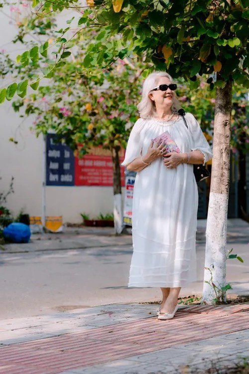 White tiered short-sleeve midi dress on tree-lined street