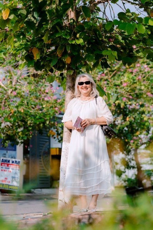 White gathered-neckline tiered midi dress with crossbody bag