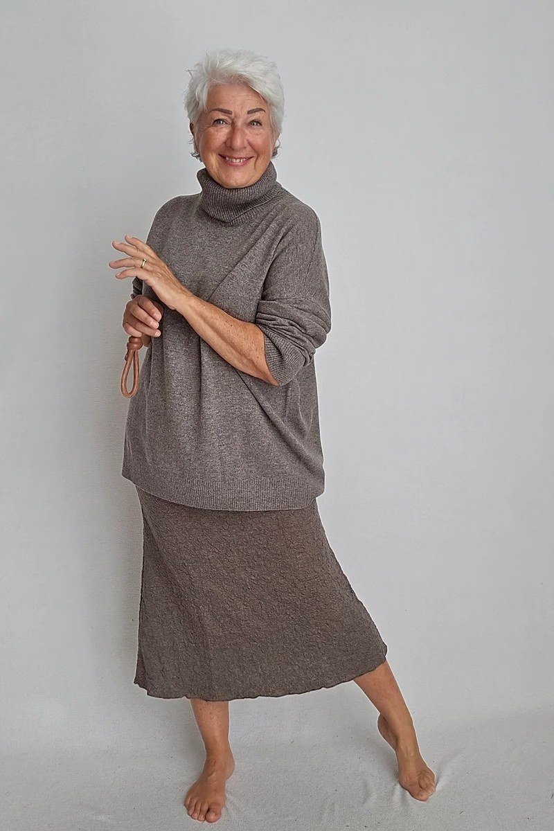 black turtleneck with champagne pleated midi skirt - classy skirt outfits for women over 60